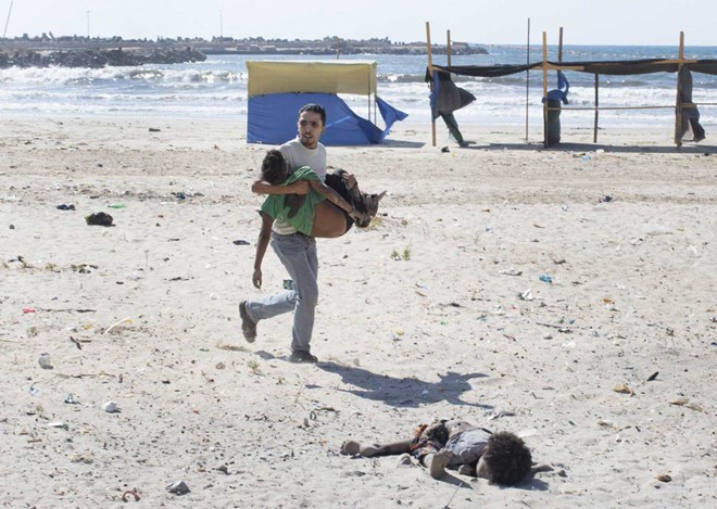 Người dân trốn chạy cuộc không kích của quân đội Israel trên dải Gaza trong tháng 7/2014.