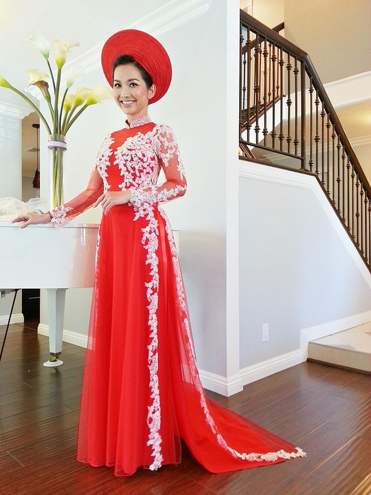 Cô diện áo dài đỏ đúng kiểu cô dâu Nam Bộ. Phần phụ kiện trắng đính dọc vai áo xuống chân mang đến cho cô dâu Kim Hiền vẻ lộng lẫy, mặn mà.