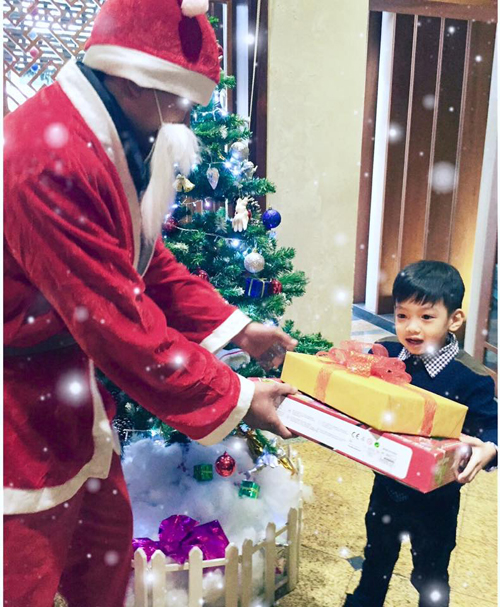 Cậu bé vui vẻ được ông già Noel tặng quà.