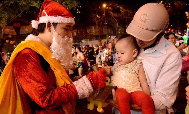 Trẻ em bất ngờ được nhiều thanh niên mặc đồ ông già Noel tìm tới tặng quà, cho kẹo.