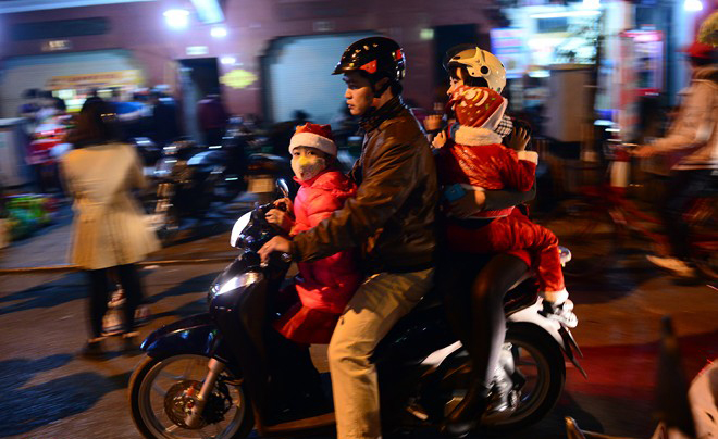 Các gia đình chở trẻ nhỏ đi chơi trên đường Đinh Tiên Hoàng, quận Hoàn Kiếm trong tiết trời 16 độ C.