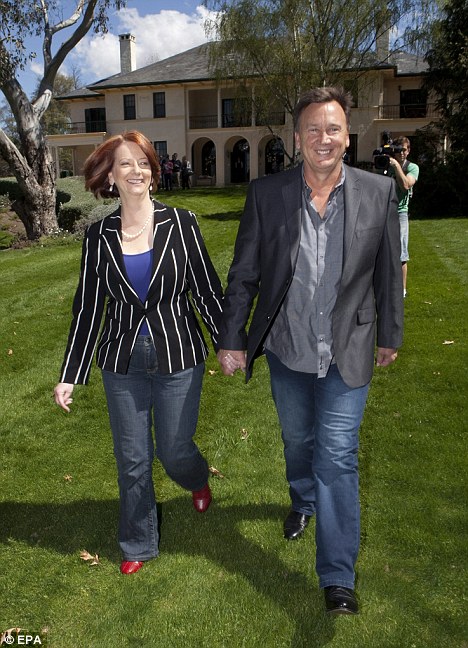 Nữ Thủ tướng Australia trẻ trung và quyến rũ bên hôn phu khi mặc trang phục jeans với áo vest kẻ.