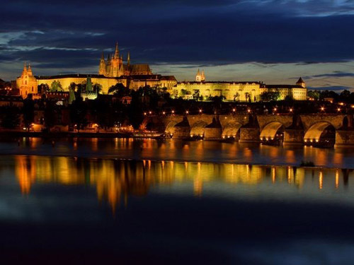 Vào ban đêm, ánh đèn từ lâu đài Prague phản chiếu xuống dòng sông Vltava trong như gương ở Prague, Cộng hòa Séc. Prague được xem là biểu tượng kiến trúc dạng lâu đài khổng lồ và phức tạp nhất thế giới.