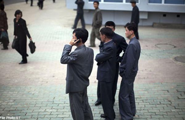 Một người đàn ông dừng nói chuyện với nhóm bạn để nghe điện thoại ở Bình Nhưỡng.