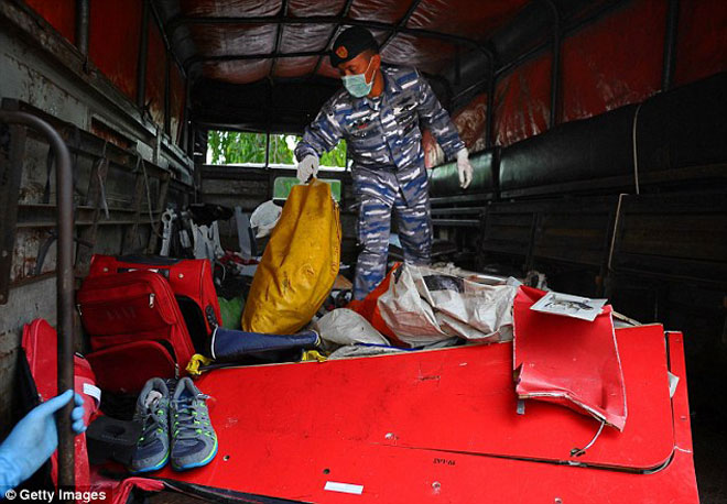 Binh sĩ của lực lượng Hải quân Indonesia sàng lọc các vật dụng cá nhân của nạn nhân từ đống đổ nát của chiếc máy bay AirAsia QZ8501.