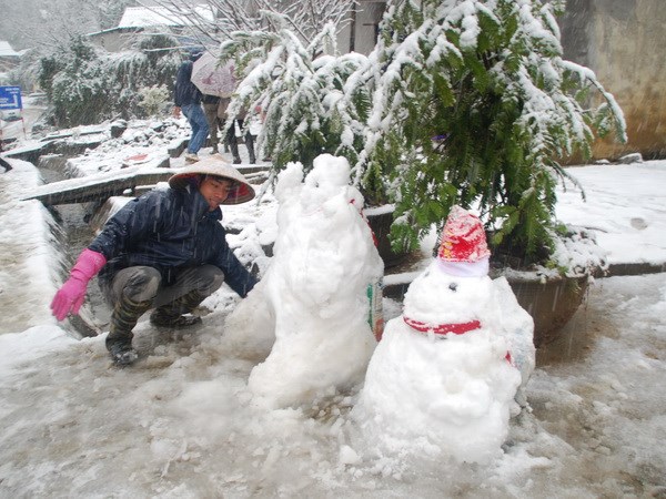 Người dân đắp người tuyết cho khách du lịch chụp ảnh.