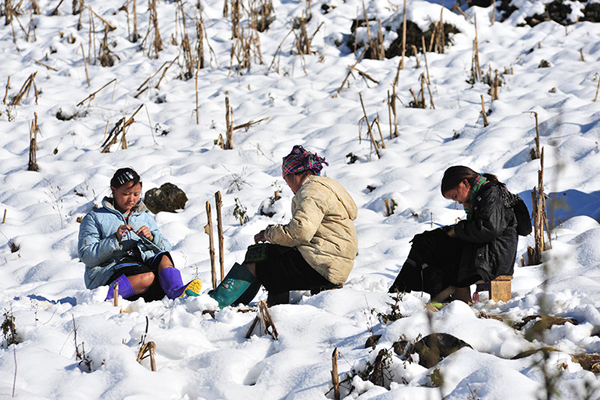 Phụ nữ dân tộc ngồi thêu giữa trời tuyết.
