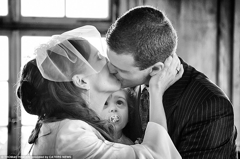 Cảnh cô con gái bé nhỏ dán mắt nhìn nụ hôn của bố mẹ trong đám cưới đoạt giải nhất chủ đề Tình yêu gia đình (mùa xuân 2014). Ảnh: Thomas Hinder, Zurich, Thụy Sĩ.