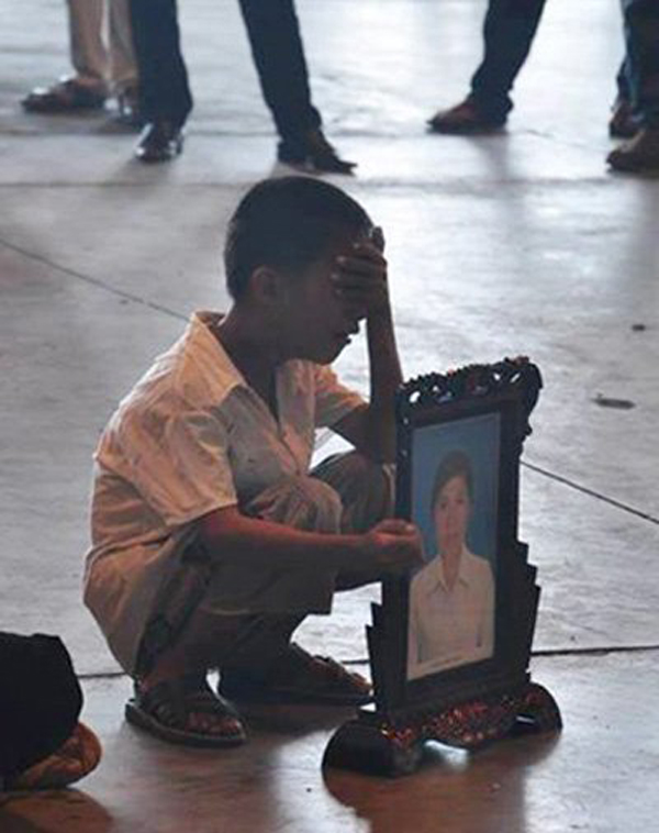 Nguyễn Ngọc Minh 10 tuổi, đi đón di hài mẹ ở sân bay sau vụ cháy xưởng may tại Nga hôm 11/9/2013. Mẹ Minh đi sang xuất khẩu lao động khi em còn học mẫu giáo, giờ em đã lên lớp 4.