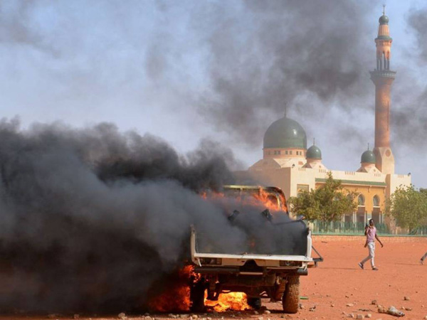 Xe cảnh sát bị phóng hỏa bởi những người biểu tình trong cuộc tuần hành phản đối Charlie Hebdo ở thủ đô Niamey (Niger) hôm 17/1.