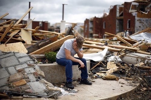 người đàn ông ngồi ôm mặt giữa tòa nhà đổ nát ở hạt Joplin, bang Missoury sau khi cơn siêu cuồng phong quét qua nhiều bang nước Mỹ vào tháng 5/2011.
