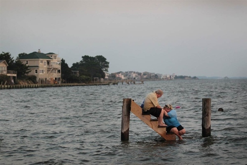 Ông Billy Stinson đang an ủi người cháu gái Erin Stinson khi cả hai đang ngồi vật vạ chờ được cứu hộ trên chiếc cầu bị nhấn chìm bởi trận lụt trong trận bão Irene quét qua nước Mỹ tháng 8/2011.