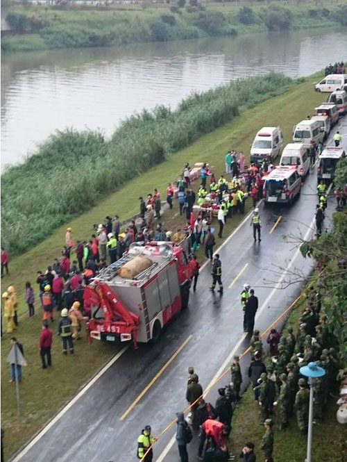 Xe cứu hỏa và xe cấp cứu chờ sẵn trên một tuyến đường ven sông để sẵn sàng đưa nạn nhân tới bệnh viện.