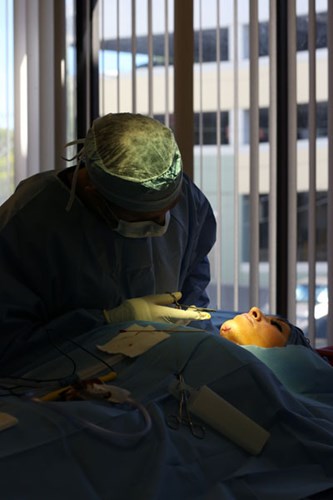 Bác sĩ đang tiến hành phẫu thuật để lấy miếng độn silicon trong cằm của cô.