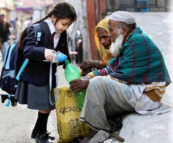 Cô bé chia sẻ nước cho những người vô gia cư.