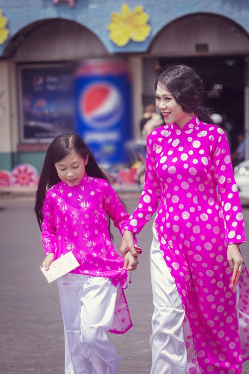 Hai mẹ con Đinh Y Nhung diện trang phục áo dài truyền thống ton-sur-ton với sắc hồng rạng rỡ xuống phố ngày Xuân.