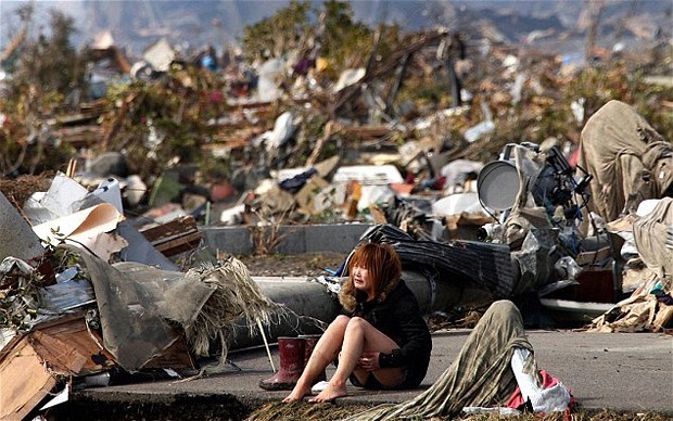 Akane Ito, 29 tuổi, ngồi trên sàn tầng 2 một căn hộ bị động đất và sóng thần tàn phá. Hình ảnh người phụ nữ ngồi khóc trong tuyệt vọng giữa đống đổ nát gây xúc động.
