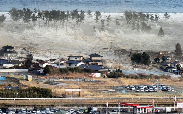 Một giờ sau khi động đất xảy ra, sóng thần từ bờ biển quét vào những khu dân cư ven biển ở tỉnh Iwanuma, kéo về sân bay Sendai.