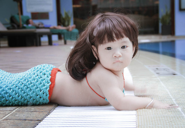 Cô bé được bố mẹ cho sắm vai nàng tiên cá nhí, thực hiện bộ ảnh kỷ niệm bên hồ bơi.