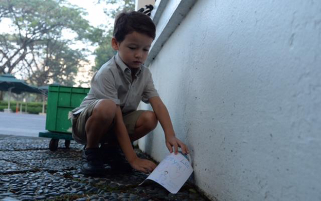 Cậu bé 5 tuổi Ryan Mackay đặt thiếp do mình tự vẽ để tưởng nhớ ông Lý. Cậu bé và mẹ, cô Sharon Tan là hai người đầu tiên tới khu tưởng niệm ông ở Istana.
