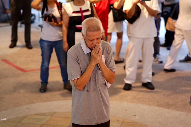 Người đàn ông đứng cầu nguyện hàng giờ khi hay tin cựu Thủ tướng qua đời.