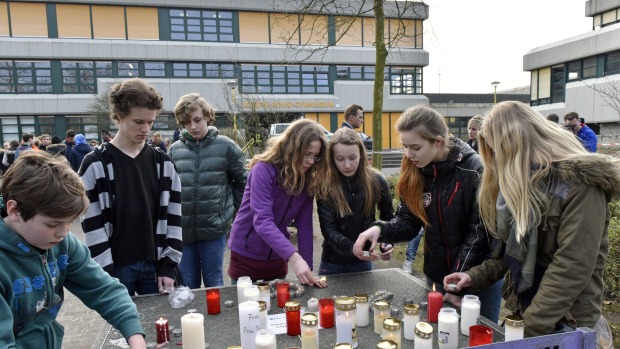 Các học sinh đứng trước trường trung học Josef-Koenig-Gymnasium ở Haltern am See để đặt những vòng hoa tưởng niệm và thắp lên những ngọn nến hy vọng.