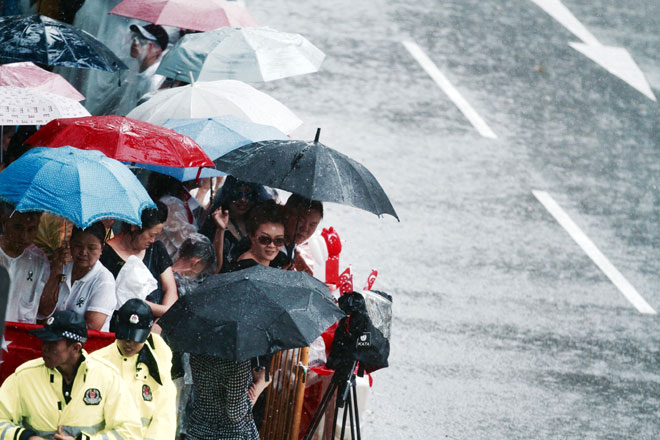 Bất chấp cơn mưa nặng hạt, hàng ngàn người dân Singapore xếp hàng dài vẫn túc trực 2 bên đường để tiễn đưa cố Thủ tướng.