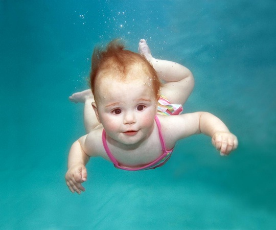 Em bé này có vẻ rất thích thú khi được bơi.