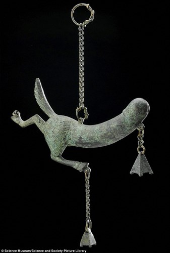Một tấm bùa có hình dáng khá giống dương vật người được làm từ đồng thiếc . Đây là một một trong những cổ vật đồ chơi tình dục được trưng bày tại Wellcome Collection.