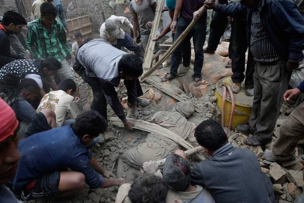 Người dân cố gắng kéo người đàn ông ra khỏi đống đổ nát sau trận động đất ở Kathmandu, Nepal.