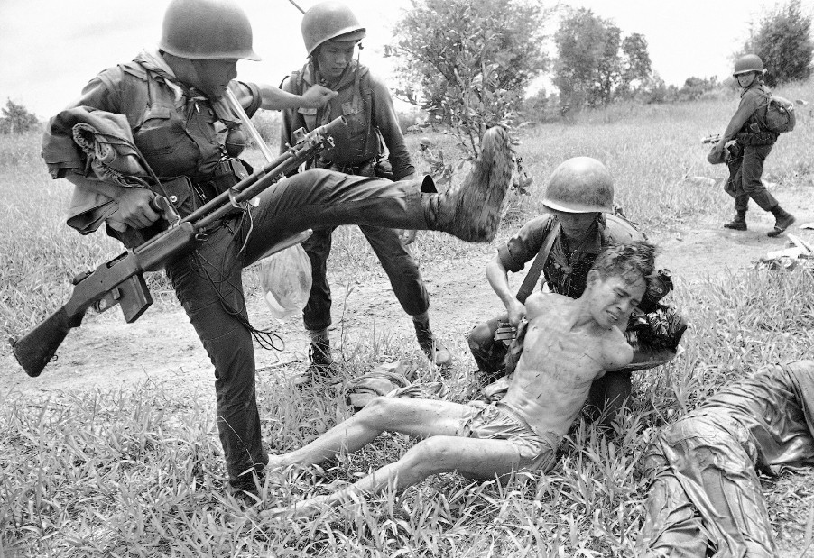 Lính VNCH đánh một người bị tình nghi là quân Giải phóng trong tháng 10/1965. Ông là một trong 15 người bị bắt sau trận càn.