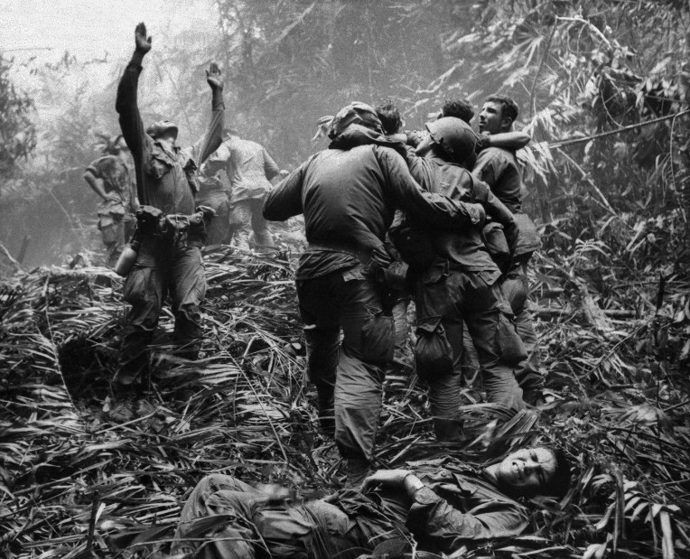 Lính Mỹ hướng dẫn trực thăng y tế thả cáng đón binh sĩ bị thương trong trận chiến ở khu rừng gần thành phố Huế tháng 4/1968.