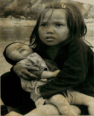 Bé gái bế em trên chiếc thuyền vượt sông phía nam Đà Nẵng trong cuộc di tản ngày 10/8/1974. Ảnh: AP