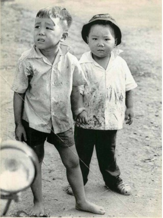 Hai bé trai nắm tay nhau hòa cùng dòng người di tản khỏi Chợ Lớn, Sài Gòn, ngày 13/5/1968. Ảnh: UPI