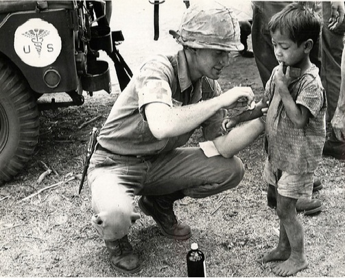 Lính Mỹ xoa thuốc vào vết thương trên tay một bé trai Việt Nam, năm 1966. Ảnh: AP