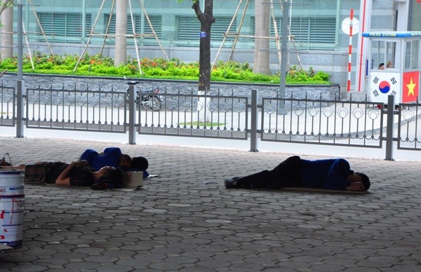 Những người công nhân ngủ trưa dưới gầm cầu vượt Daewoo trên đường Liễu Giai để tránh nắng vào buổi trưa.