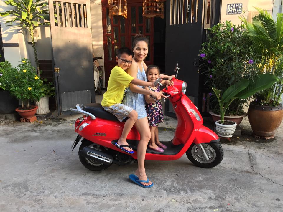 Hồng Ngọc chở hai con đi chơi bằng xe máy. Hai em bé có vẻ thích thú khi lần đầu được ngồi xe máy đi chơi không phải ô tô như ở Mỹ.