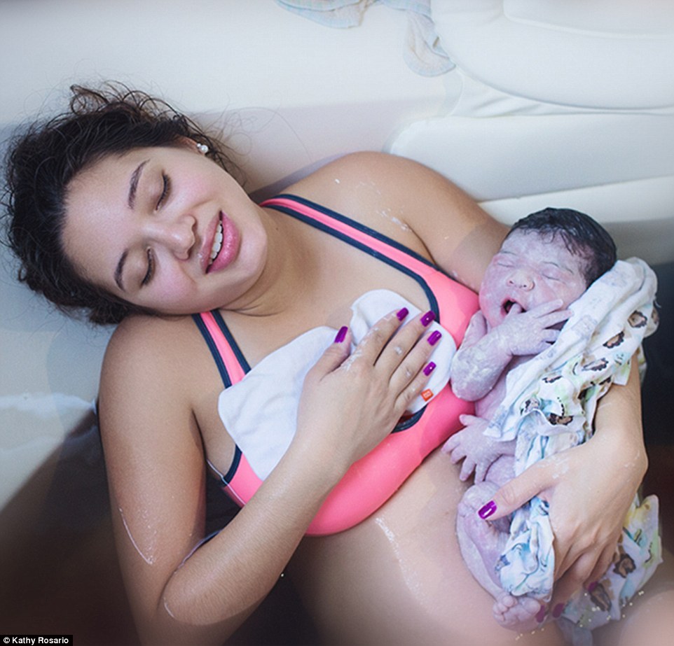 Sau khi sinh con, bà mẹ được hai nhân viên hộ sinh đưa ra khỏi bồn tắm.