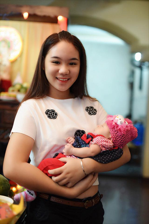 Khánh Ngân - con gái lớn của Trịnh Kim Chi - bế em bé rất thuần thục và có chiều cao vượt trội.
