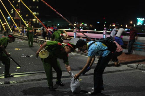 Một số cán bộ, chiến sĩ Phòng cảnh sát trật tự Công an Đà Nẵng cùng các bạn trẻ thu dọn rác trên cầu Sông Hàn (Đà Nẵng) sau lễ hội pháo hoa.
