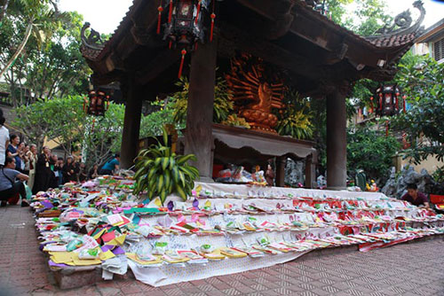 Hàng trăm lễ của người dân đặt xung quanh các bậc thang dưới chân tượng Phật.