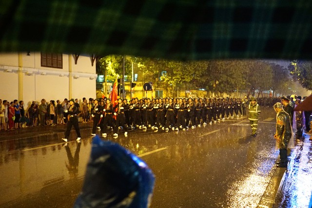 Đến khoảng 9 giờ, bất ngờ cơn mưa lớn đổ ập xuống đường phố. Đoàn diễu hành tiếp tục buổi tổng duyệt trong mưa.