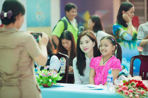 Hoa hậu chụp ảnh cùng một em học sinh trong chương trình.