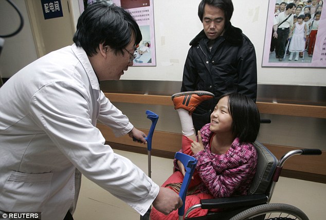 11 tuổi, cô bé nói chuyện với một bác sĩ tại Trung tâm Phục hồi chức năng Trung Quốc ở Bắc Kinh vào năm 2007 sau khi lắp chân giả. Ảnh: Reuters.