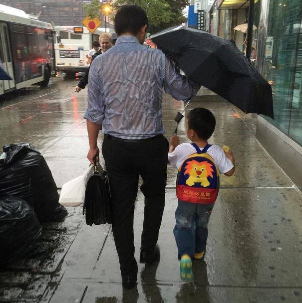 Cha chịu ướt, cầm ô che mưa cho con trai gây xúc động mạnh.