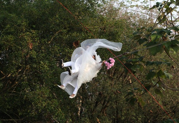 Một đôi vợ chồng Thái Lan tung bay bằng cáp trong khi đang thực hiện lễ thành hôn.