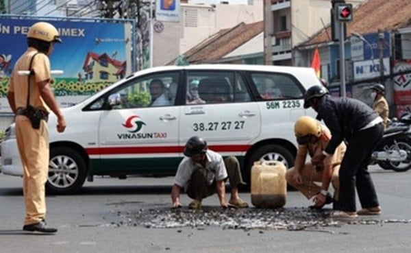 Người CSGT này đã không ngại ra tay giúp thu gom cá vào can nhựa giúp người dân sau vụ va chạm.