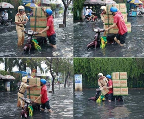 Trong dòng nước ngập, Trung sĩ Nguyễn Xuân Minh vừa nhận công tác tại Đội CSGT công an quận 11 đã không nề hà nước ngập, chạy đến treo dùi cui rồi dỡ từng thùng hàng lên chỗ khô.