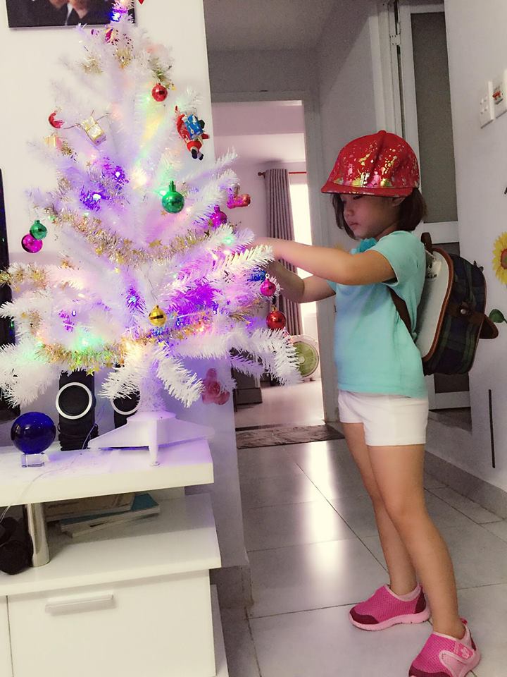 Cô bé được mẹ Thu Phượng chụp ảnh bên cây thông Noel tại nhà.
