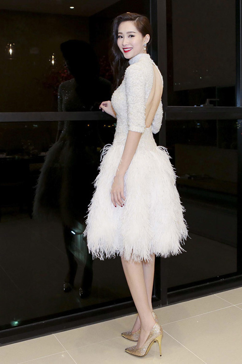 Hoa hậu Đặng Thu Thảo tới dự một sự kiện tại TP HCM trong bộ đầm trắng thiết kế lông vũ ấn tượng, nổi bật và sang trọng. Ở phía trước, bộ trang phục cso vẻ kín đáo, nhưng lại hở lưng giúp Hoa hậu Việt Nam 2012 khoe được vẻ quyến rũ, gợi cảm